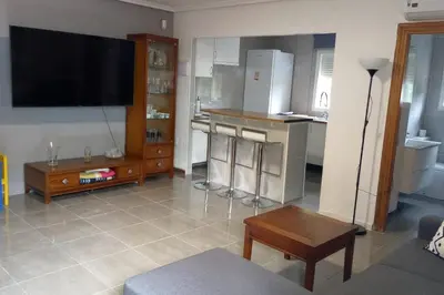 a living room with a tv and a kitchen at Casa Tena in Partida de La Cañada