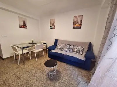 a living room with a blue couch and a table at PINAMAR in Puerto de Sagunto