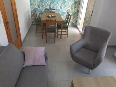 a living room with a couch and a table and chairs at Neptuno Playa San Antonio in Cullera