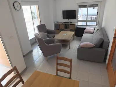a living room with a couch and chairs and a table at Neptuno Playa San Antonio in Cullera
