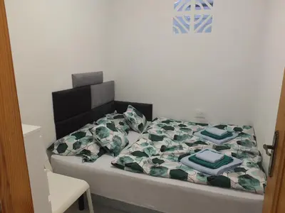 a bed with a black headboard and blue pillows on it at Neptuno Playa San Antonio in Cullera