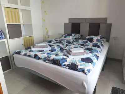 a bed with a blue and white comforter in a bedroom at Neptuno Playa San Antonio in Cullera