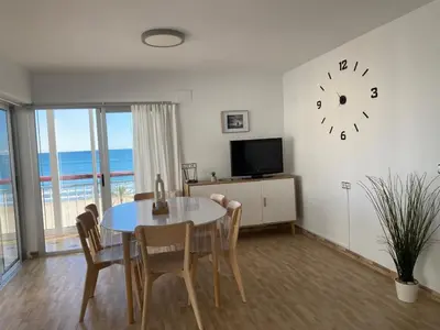 a dining room with a table and a clock on the wall at Cara al mar in Cullera