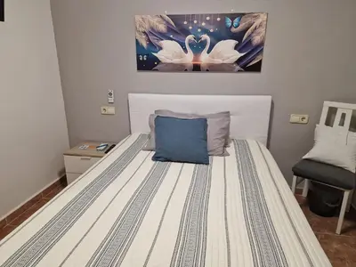 a bedroom with a bed with a blue pillow on it at Habitaciones Zoe in Puerto de Sagunto
