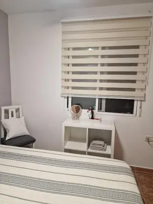 a bedroom with a bed and a window with a blind at Habitaciones Zoe in Puerto de Sagunto