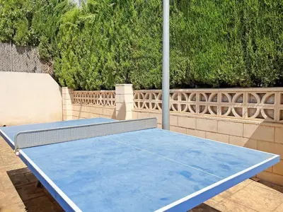 a blue ping pong table in front of a fence at Global Vacacional, Apartamento con gran terraza en Canet in Canet de Berenguer