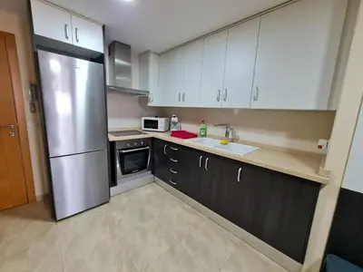a kitchen with white cabinets and a stainless steel refrigerator at Las Jarcias 3A in Moncófar