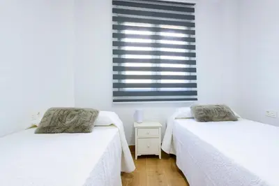 two beds in a room with white walls and a window at Un endroit accueillant avec vue à Jerica in Jérica