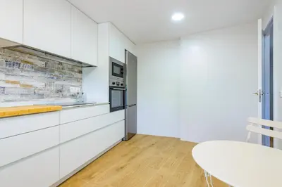 a kitchen with white cabinets and a white table at Un endroit accueillant avec vue à Jerica in Jérica