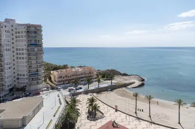 a view of a beach with palm trees and a building at Faromar, I-10-M in Cullera