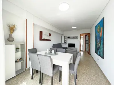 a dining room with a white table and chairs at Global Vacacional, Apartamento en primera línea de playa, Canet de Berenguer in Canet de Berenguer