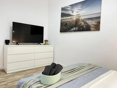 a white bedroom with a tv and a dresser at Rodrigues 15 in Valencia