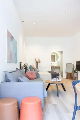 a living room with a blue couch and orange stools at VLC HOST - Cubells in Valencia