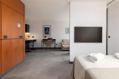 a hotel room with a tv and a bedroom at Calatrava by Alma Suites in Valencia