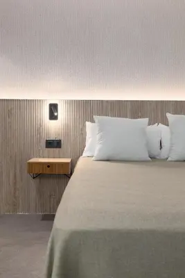 a bedroom with a large bed with white pillows at Calatrava by Alma Suites in Valencia