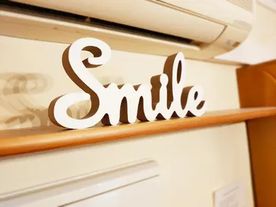 a sign that says smile on a shelf at Global Vacacional, Apartamento con piscina y terraza en Canet playa in Canet de Berenguer