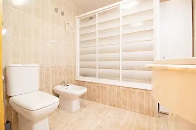 a bathroom with a toilet and a sink at Global Vacacional, Apartamento con piscina y terraza en Canet playa in Canet de Berenguer