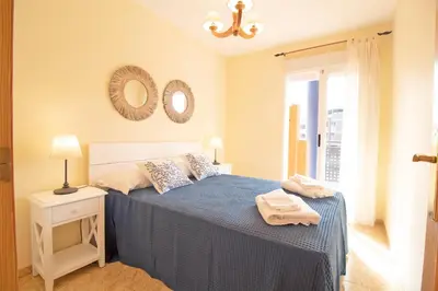 a bedroom with a bed and two mirrors on the wall at Global Vacacional, Apartamento con piscina y terraza en Canet playa in Canet de Berenguer