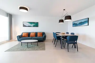 a living room with a couch and a table at Global Vacacional, Moderno apartamento con dos terrazas con vistas al mar y a la montaña in Canet de Berenguer