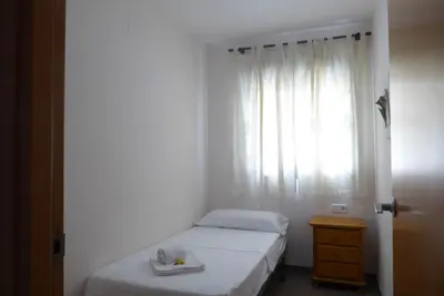 a small bedroom with a bed and a window at Coqueto apartamento de 3 habitaciones by Hometels in Puerto de Sagunto