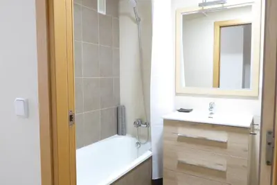 a bathroom with a tub and a sink and a mirror at Coqueto apartamento de 3 habitaciones by Hometels in Puerto de Sagunto