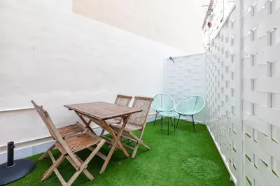 a table and chairs on a balcony with green grass at Belmar Apartments in Valencia