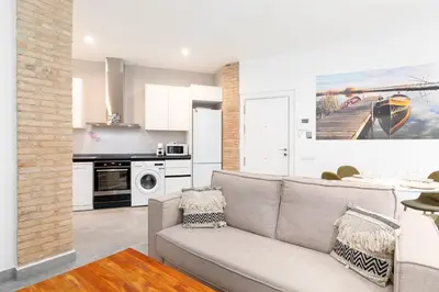a living room with a couch and a kitchen at Belmar Apartments in Valencia