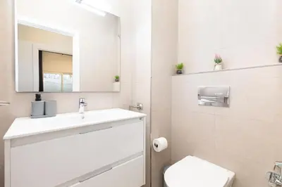 a bathroom with a sink and a toilet and a mirror at Belmar Apartments in Valencia