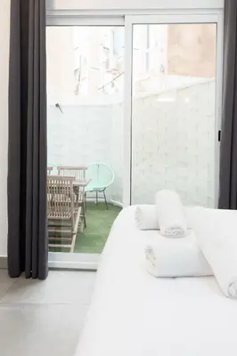 a bedroom with a white bed and a large window at Belmar Apartments in Valencia