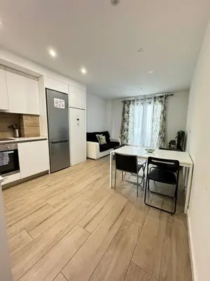 a kitchen and a living room with a table and chairs at Escolano Rooms MAS 11 Noches in Valencia