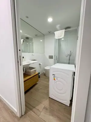 a bathroom with a sink and a washing machine at Escolano Rooms MAS 11 Noches in Valencia