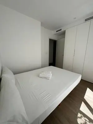 a white bed with a towel on it in a room at Escolano Rooms MAS 11 Noches in Valencia