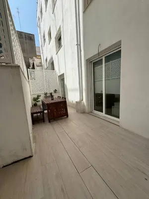 an outdoor patio with a table and chairs on a building at Escolano Rooms MAS 11 Noches in Valencia