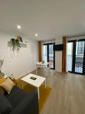 a living room with a couch and a table at Escolano Rooms MAS 11 Noches in Valencia