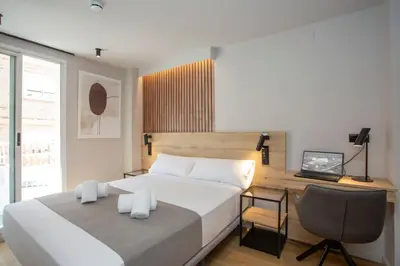 a bedroom with a bed and a desk with a computer at Aila II Hotel Boutique by SingularStays - Digital Access in Burjasot