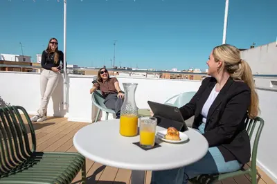 two women sitting at a table with a plate of food at Aila II Hotel Boutique by SingularStays - Digital Access in Burjasot