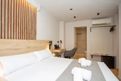 a bedroom with a white bed and a chair at Aila II Hotel Boutique by SingularStays - Digital Access in Burjasot