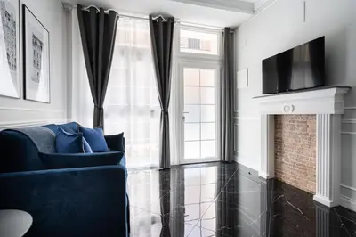 a living room with a blue couch and a fireplace at Le Parisien de COUP DE COEUR APPARTEMENTS in Valencia