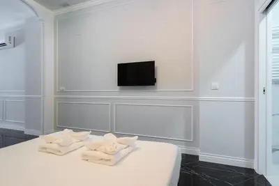 a white room with two towels on a bed at Le Parisien de COUP DE COEUR APPARTEMENTS in Valencia