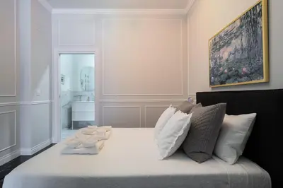 a bedroom with a bed with white sheets and pillows at Le Parisien de COUP DE COEUR APPARTEMENTS in Valencia