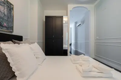 a white bed with white pillows on top of it at Le Parisien de COUP DE COEUR APPARTEMENTS in Valencia