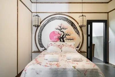 a bedroom with a bed with a painting on the wall at Le Japonais de COUP DE COEUR APPARTEMENTS in Valencia