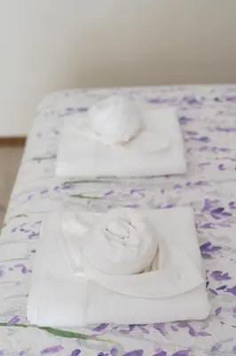 a group of three white towels on a bed at Le Provençal de COUP DE COEUR APPARTEMENTS in Valencia