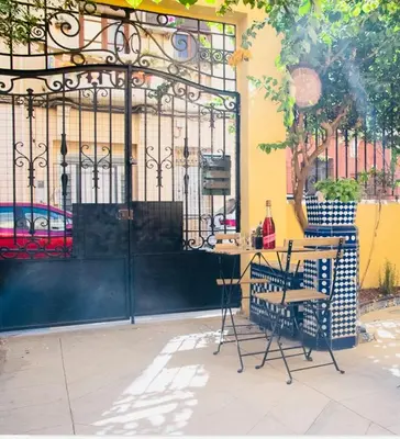a table and chairs in front of a building with a gate at Habitación con Baño privado 1 cama de matrimonio in Valencia