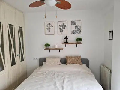 a bedroom with a bed and a ceiling fan at Cozy Rustic Home in Playa Pobla de Farnals