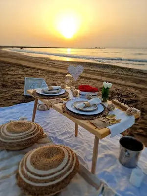 a picnic table on the beach with the sunset at Cozy Rustic Home in Playa Pobla de Farnals