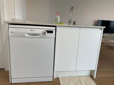 a white kitchen with a dishwasher and a counter at VerdeMar 5 (Playa Puerto de Sagunto) in Puerto de Sagunto