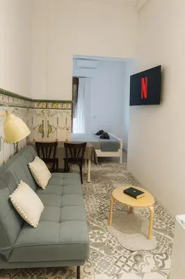 a living room with a couch and a bed at Habitación doble en Ruzafa con baño privado in Valencia