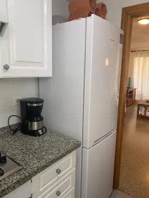 a white refrigerator in a kitchen with a counter top at Apartamento frente al mar en Playa Patacona in Valencia