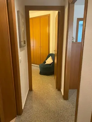 a hallway with a green ottoman in a room at Apartamento frente al mar en Playa Patacona in Valencia